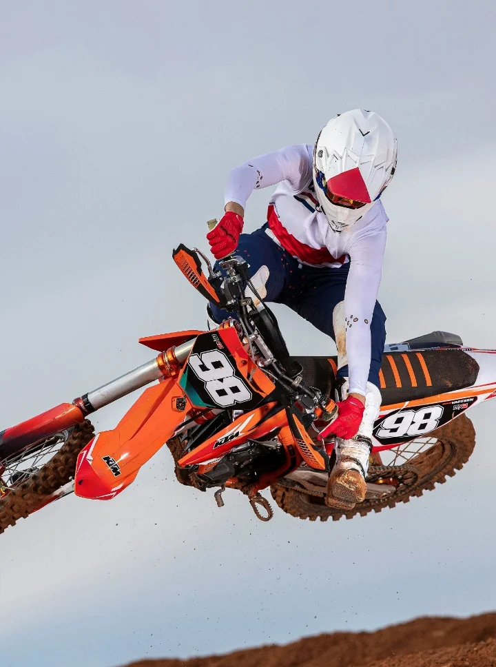 Person Riding Motocross Bike with Impact Detect Integrated into MX Helmet